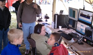Boy Scouts get a taste of amateur radio with Dean Madsen, N0XR, at the software-defined radio station. Photo by Tom Reis, N0VPR